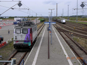 26.07.2004: Westfälische Almetalbahn (WAB) nr. 54 ved persontogsperronen i Mukran Port. Selv om sporene i baggrunden ikke direkte er overfyldte, så vidner de oprangerede godsvogne dog om havnens tidligere vigtige funktion som transithavn for især godstrafikken.