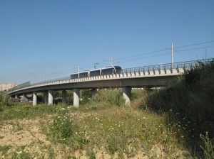 03.04.2009: Den ca. 200 m. lange bro, der - mellem Pragal og Ramalha - fører over motorvejen mellem Lissabon og Setúbal (man kan lige ane et par biler inde under broen mellem søjlerne). Stoppestedet Ramalha ligger for enden af broen til højre lige uden for billedet.